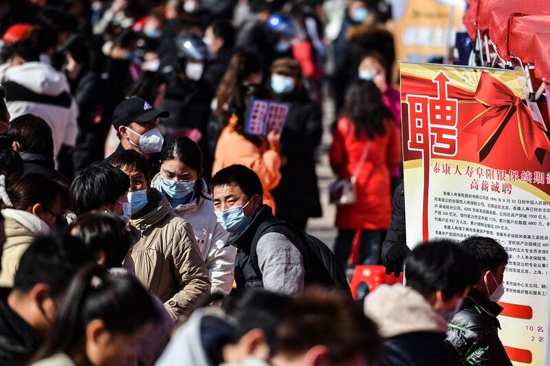 2023年1月29日，安徽省阜阳市参加招聘会。有分析指出，两项数据此消彼长昭示着学历崇拜这一观念的退潮，也显示出中国年轻人在面临经济下行导致就业风险时，作出了追求安稳的集体选择。（法新社）