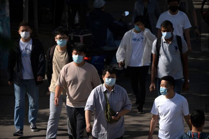 2023年5月23日,北京街道上的行人戴上了口罩。(美联社图片)